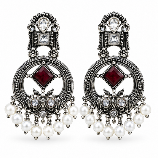 Handcrafted oxidised owl-inspired chandbali earrings with ruby-maroon crystal stone, sparkling AD stones, and elegant pearl hangings.